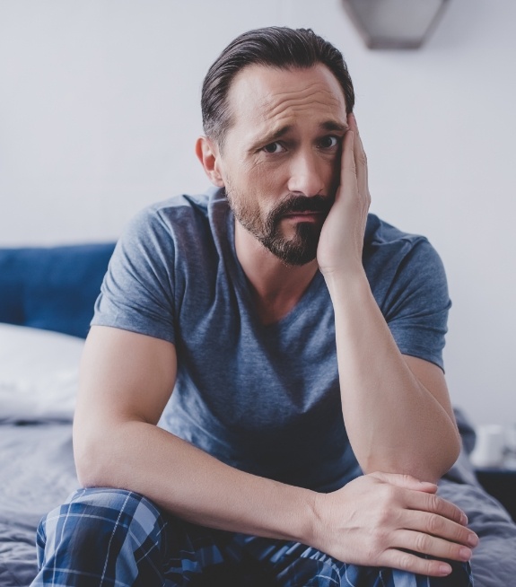 Man holding the side of his face in pain