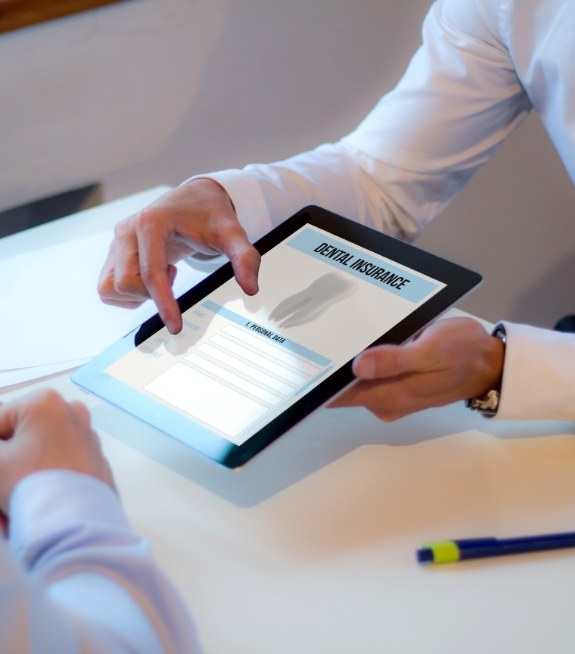 Two people looking at dental insurance form on a tablet