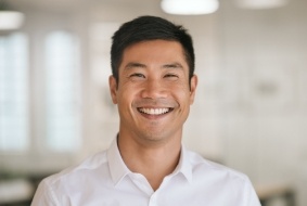 Smiling man in white collared shirt