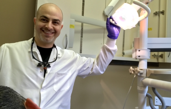 Saint Johns dentist smiling while pulling dental light from top of treatment chair