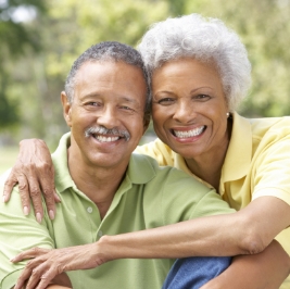 Senior man and woman hugging outdoors