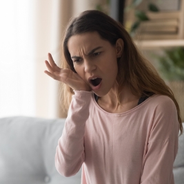 Woman wincing and holding her jaw in pain