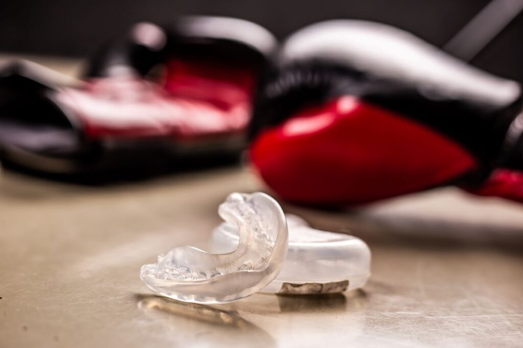 A pair of boxing gloves and a sports mouthguard.